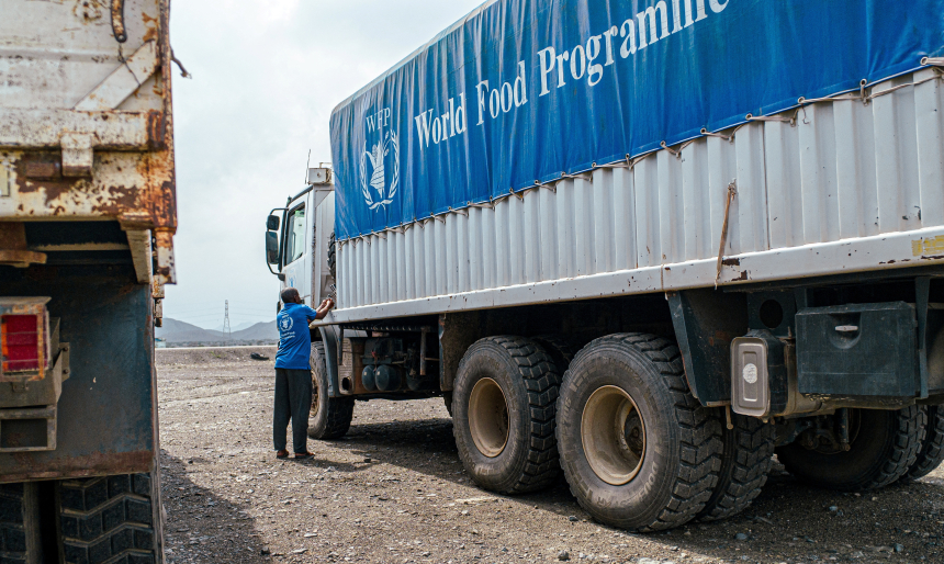 Mann står ved siden av lastebil fra Verdens matvareprogram (WFP) i Sudan