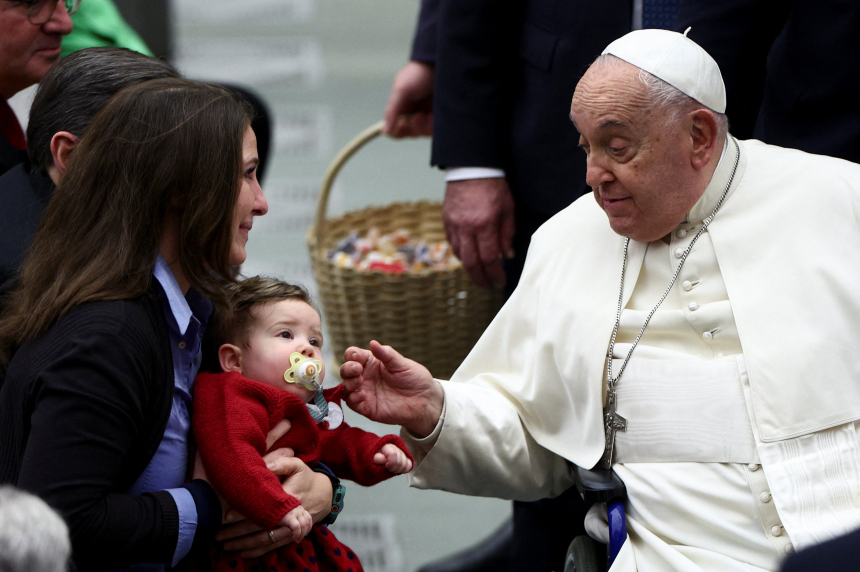 Pave Frans hilser på et barn under en generalaudiens i Paul VI-salen