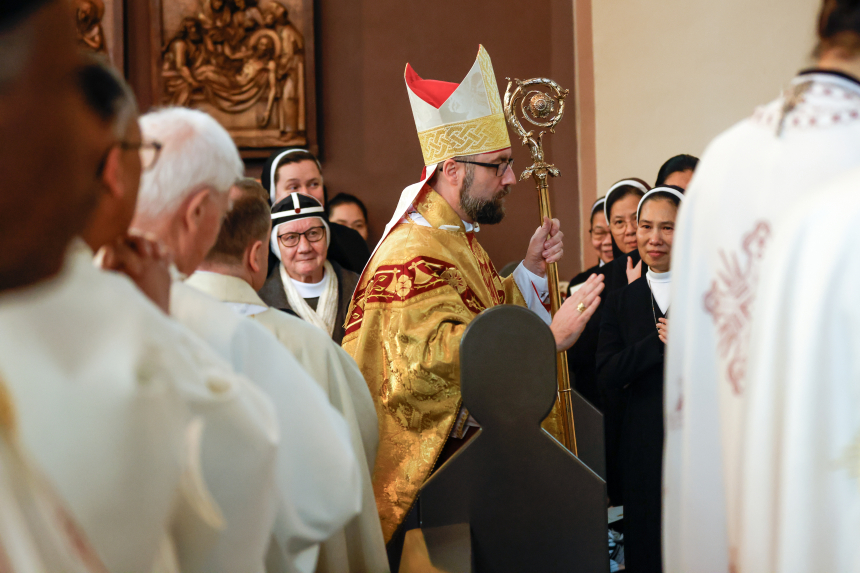 Biskop Fredrik Hansen med mitra og bispestav går nedover midtgangen i en fullsatt St. Olav domkirke