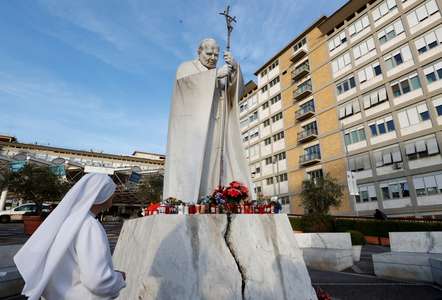 En nonne står ved siden av statuen av pave Johannes Paul II utenfor Gemelli-sykehuset i Roma